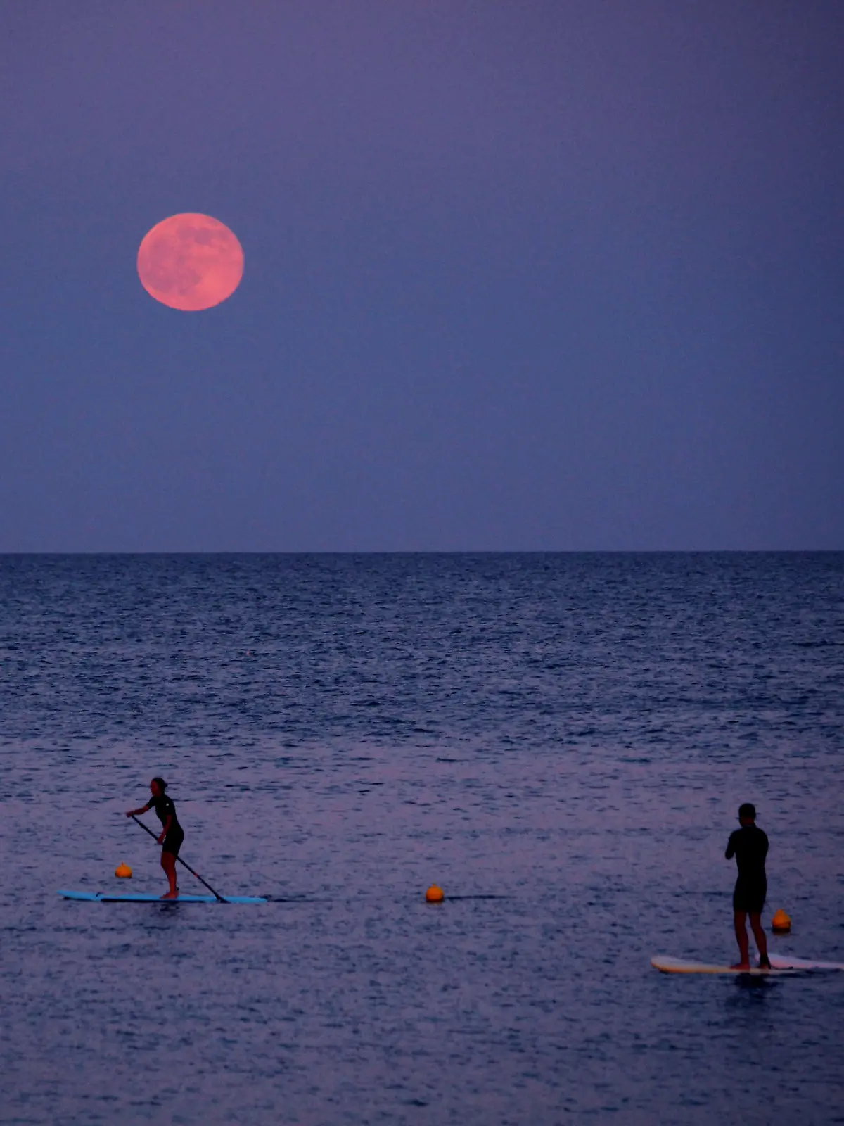 Stand-up-Paddler unter dem Erdbeermond in Barcelona im Jahr 2016.
