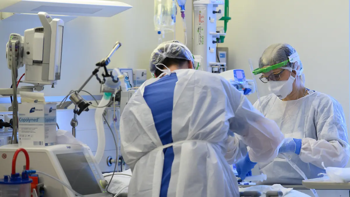 ARCHIV - 19.01.2021, Sachsen, Pulsnitz: Intensivpflegerinnen sind in Schutzkleidungen auf der Intensivstation einer Klinik mit der Versorgung von Corona-Patienten beschäftigt. Das statistische Bundesamt äußert sich am Morgen zu Beschäftigten und Bruttoverdiensten in der Pflege für die Jahre 2020/2021. Foto: Robert Michael/dpa-Zentralbild/dpa +++ dpa-Bildfunk +++