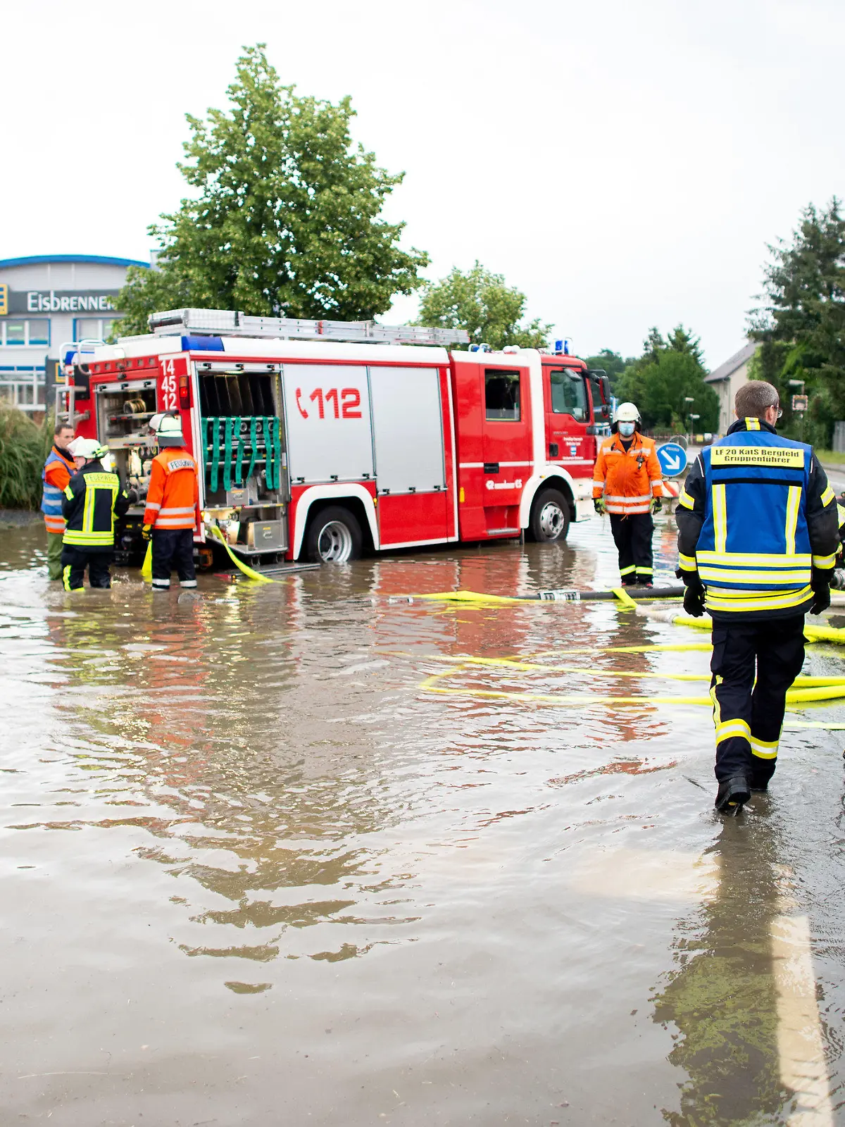 13.06.2020, Niedersachsen, Weyhausen: Ein Einsatzfahrzeug der Feuerwehr steht auf der überschwemmten und gesperrten Bundesstraße B188 im Landkreis Gifhorn vor einem Supermarkt, dessen Parkplatz durch Starkregen überflutet wurde und abgepumpt werden muss. Einzelne Gewitter haben am Samstag in Niedersachsen örtlich heftigen Regen gebracht. Foto: Hauke-Christian Dittrich/dpa +++ dpa-Bildfunk +++