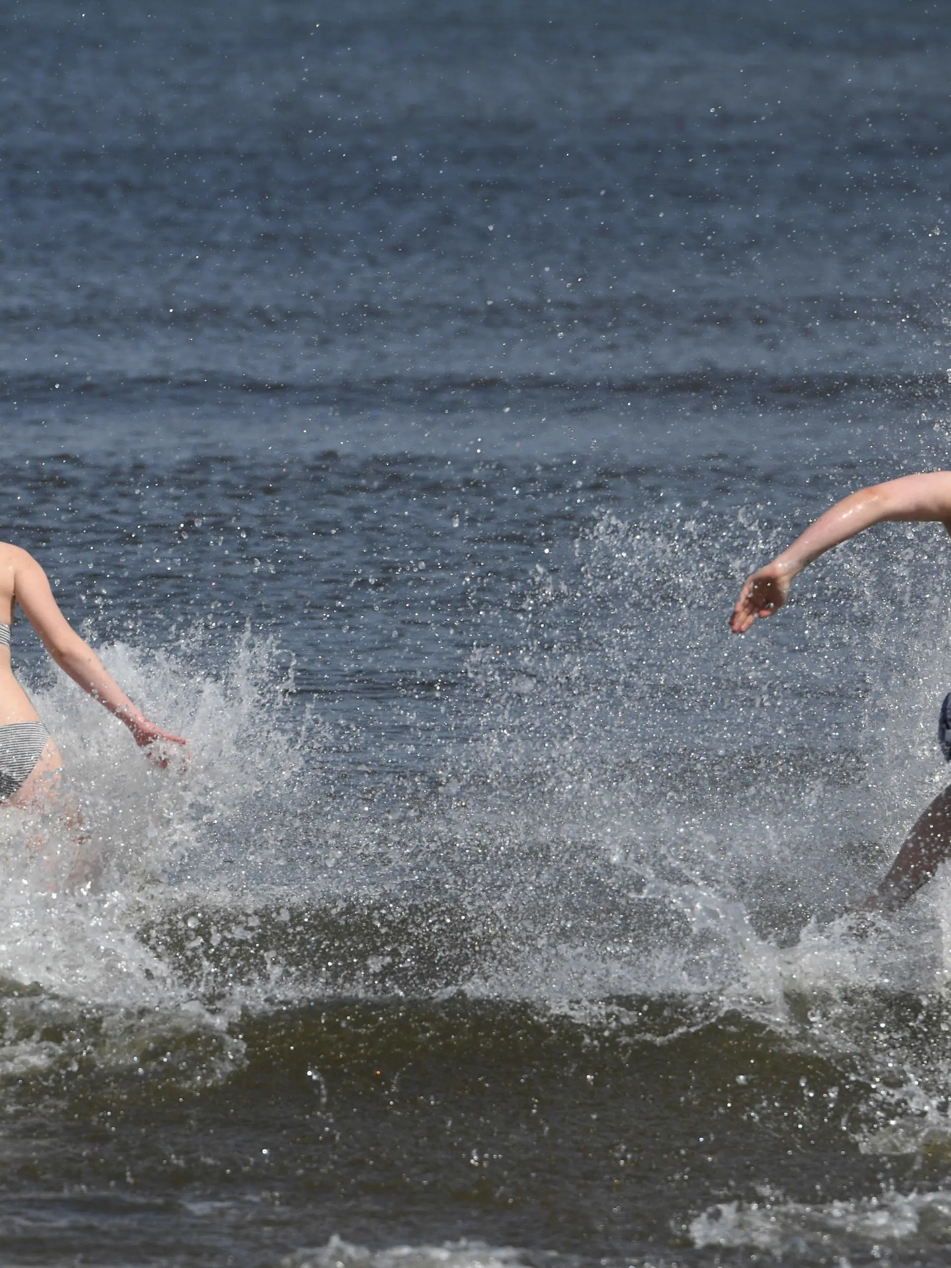 ARCHIV - 01.05.2020, Mecklenburg-Vorpommern, Ahlbeck: Junge Leute laufen bei frühlingshaftem Wetter in die Ostsee. Vor allem in wärmeren Sommern wie 2003, 2018 und 2019 wurden Fälle bekannt, einige Patienten starben: Eine Infektion mit sogenannten Vibrionen kann beim Baden in der Ostsee zur Gefahr werden. Und das künftig wohl viel stärker als bisher. (zu dpa «Folge der Erderwärmung: Mehr Infektionen mit Vibrionen erwartet») Foto: Stefan Sauer/dpa +++ dpa-Bildfunk +++