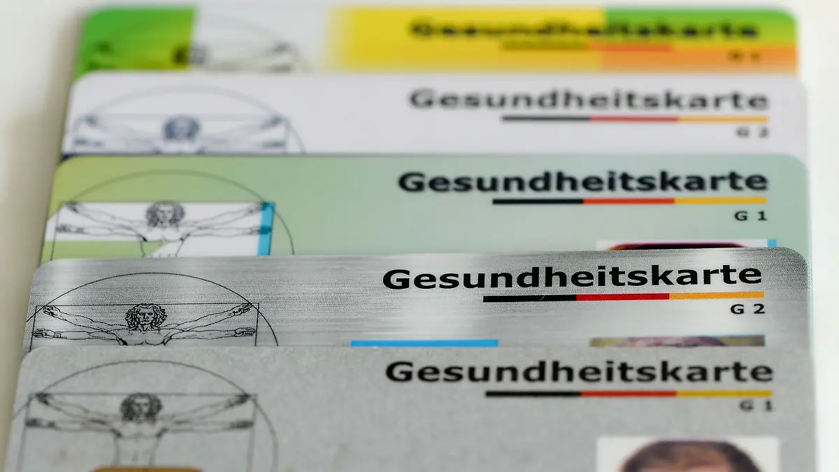 Gesundheitskarten verschiedener Krankenkassen liegen auf einem Tisch.