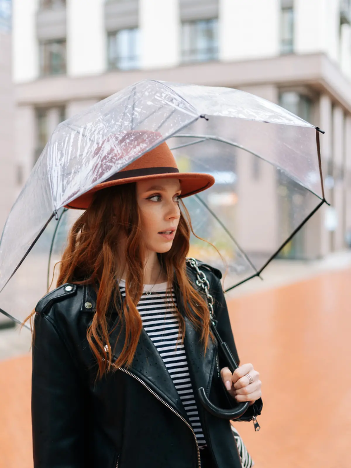 Frau steht im Regen und schaut genervt. Wo ist der Sommer 2024? 