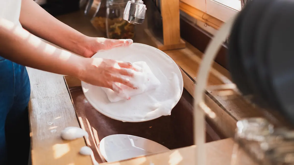 Close up maid housewife washing cleaning dishes in kitchen