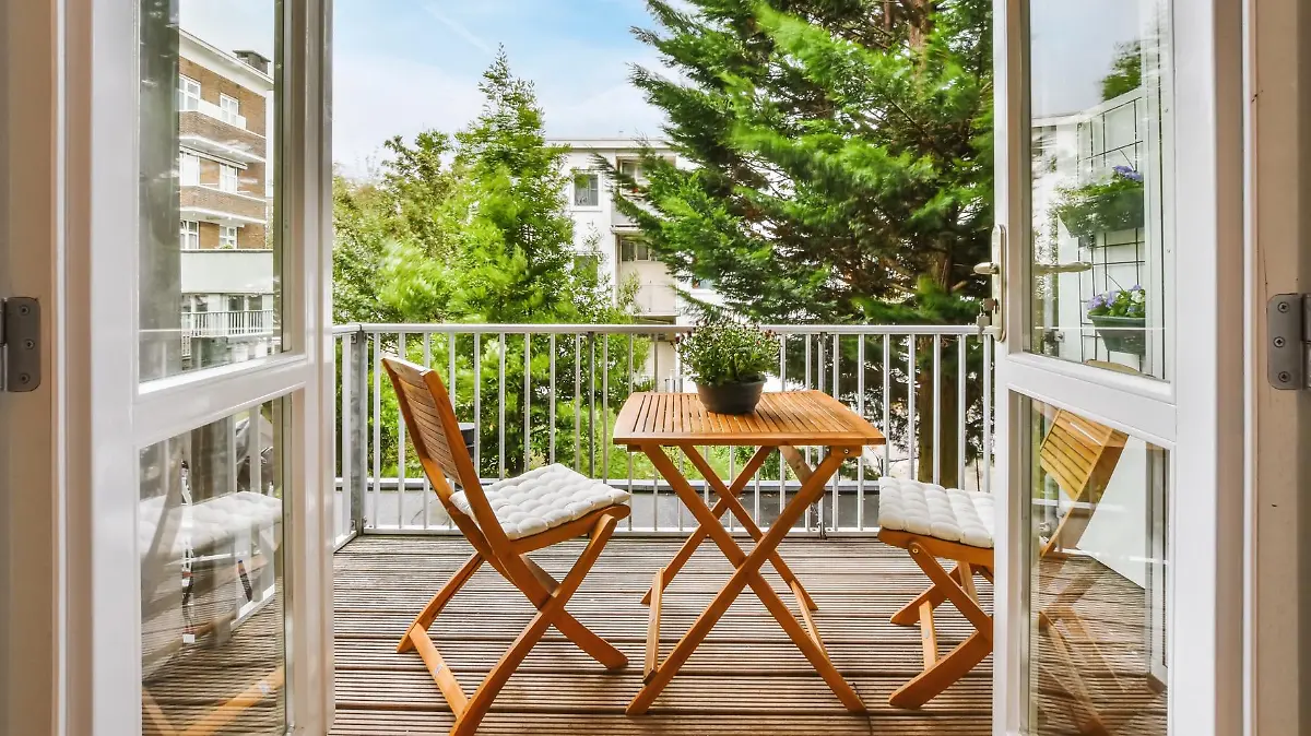 Blick auf den Balkon mit Holzmöbeln.