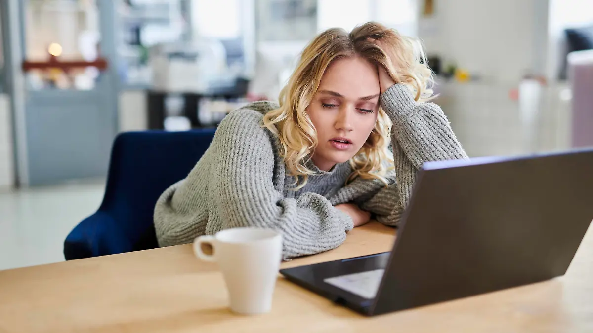 Tired young woman sitting at desk in office with laptop model released, Symbolfoto property released, MMIF00338