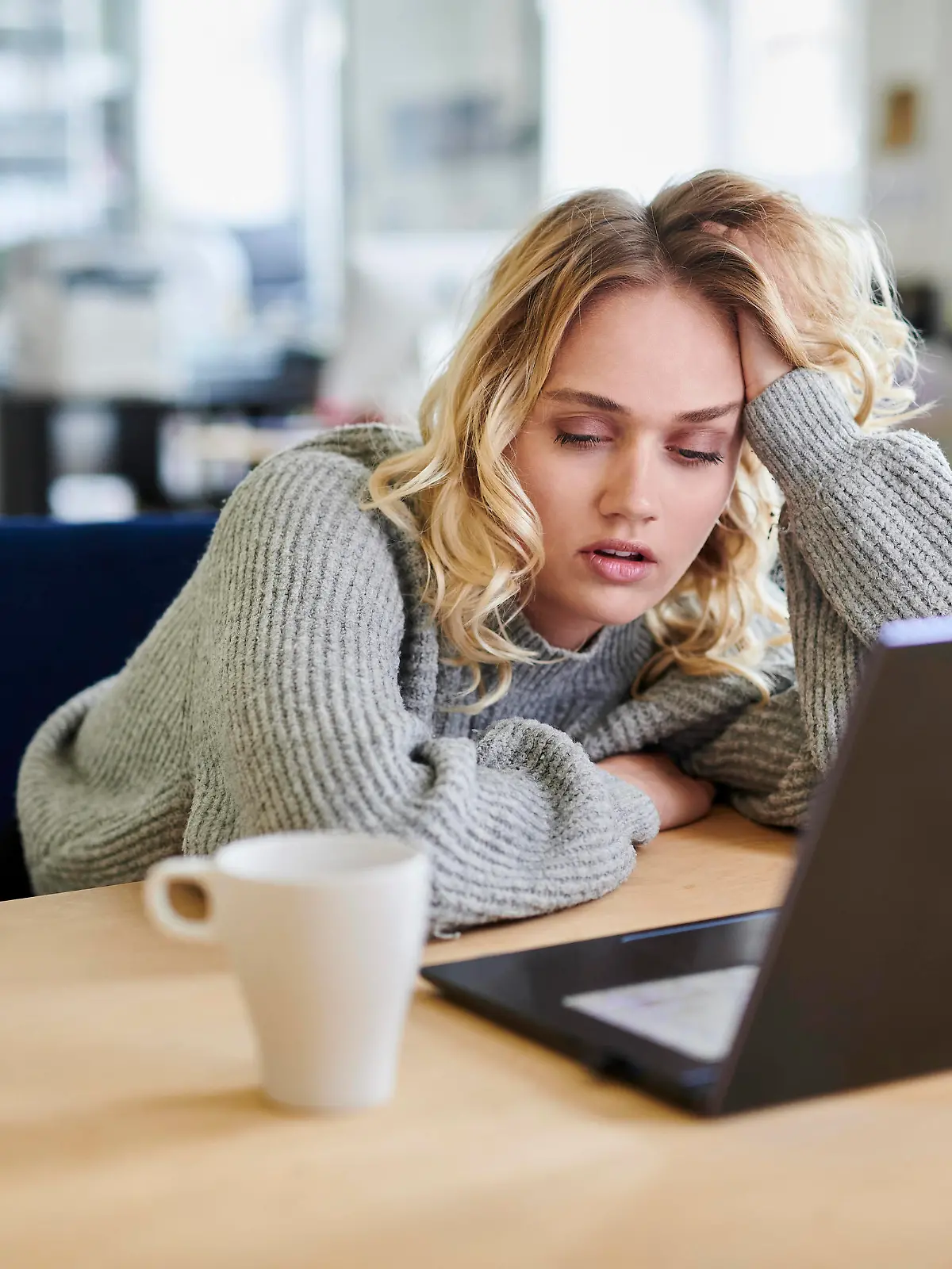 Tired young woman sitting at desk in office with laptop model released, Symbolfoto property released, MMIF00338