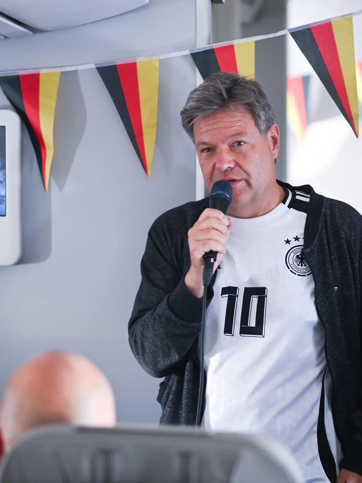 19.06.2024, Brandenburg, Schönefeld: Robert Habeck (Bündnis 90/Die Grünen), Bundesminister für Wirtschaft und Klimaschutz, spricht während des Flugs nach Südkorea in einem Presshintergrundgespräch im Rahmen seiner Ostasien-Reise. Habeck reist bis zum 23. Juni zunächst nach Südkorea und anschließend China. Foto: Sebastian Christoph Gollnow/dpa +++ dpa-Bildfunk +++
