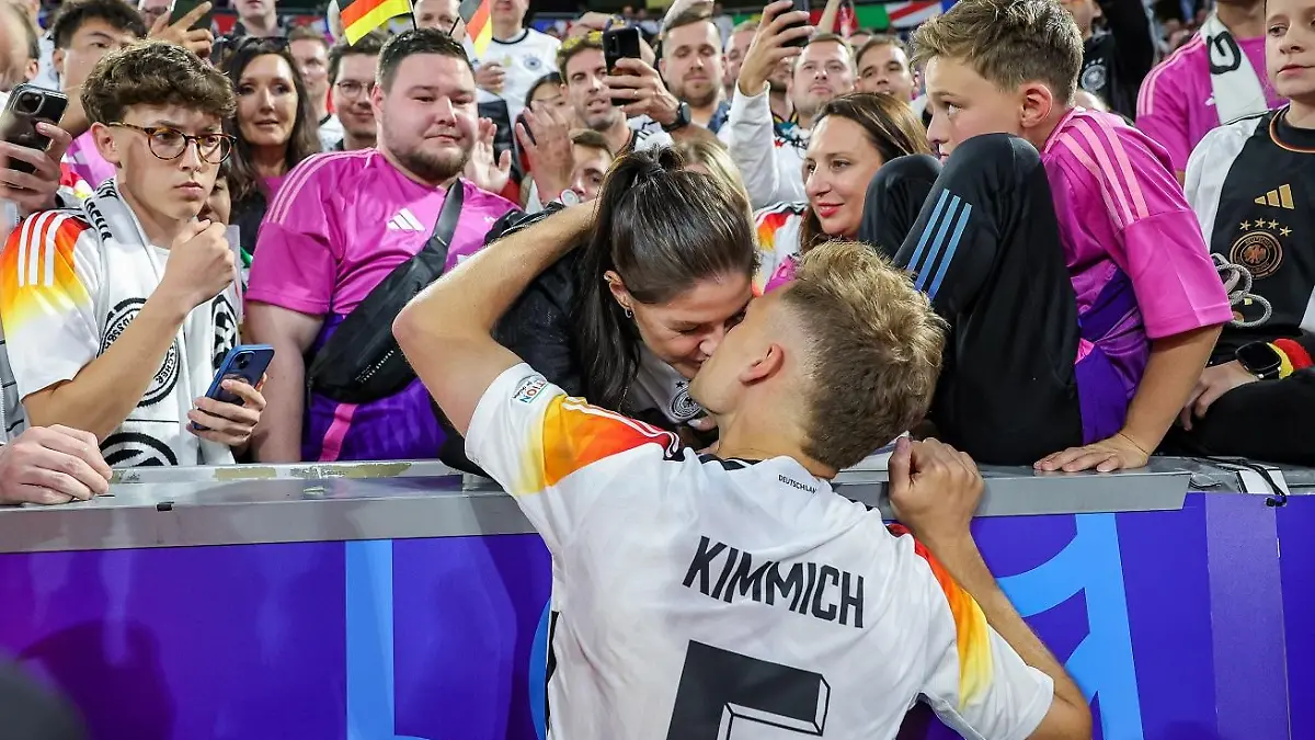 Joshua Kimmich küsst Lina Meyer nach dem Sieg von Deutschland bei der Fußball-EM 2024 gegen Ungarn.