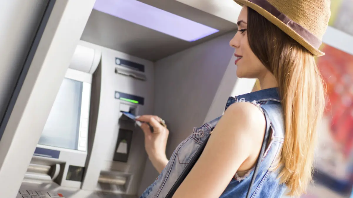 Young woman withdrawing money at the ATM.