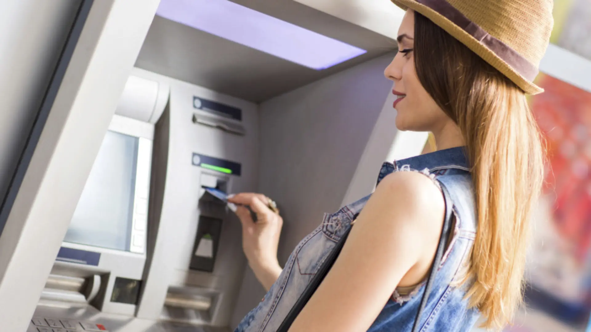 Young woman withdrawing money at the ATM.