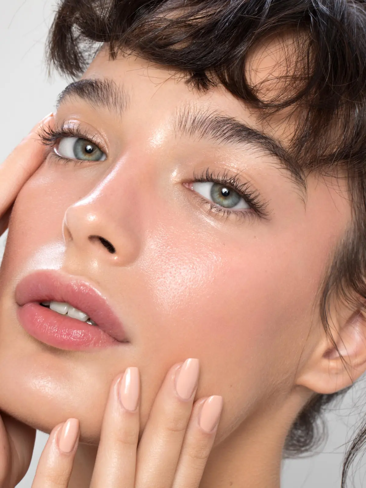 Close up studio shot of a beautiful woman with perfect skin, she touching her face