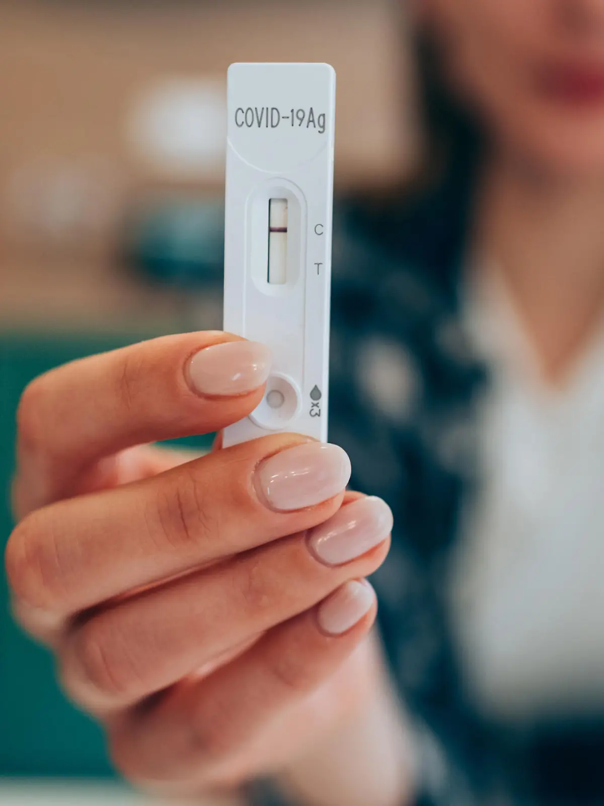 Close-up shot of woman's hand holding a negative test device. Young woman showing her negative Coronavirus/Covid-19 rapid test. Focus is on the test.