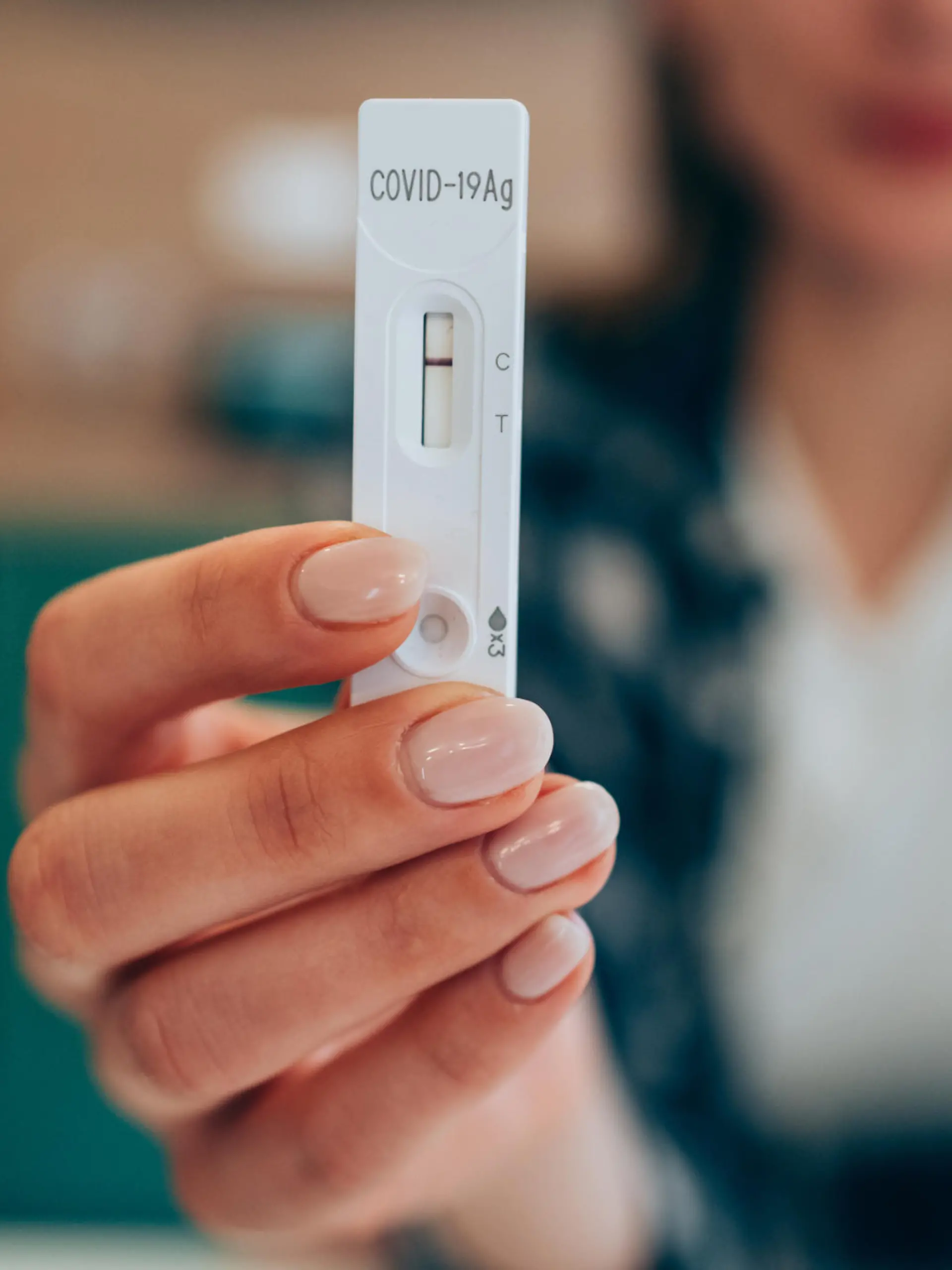Close-up shot of woman's hand holding a negative test device. Young woman showing her negative Coronavirus/Covid-19 rapid test. Focus is on the test.