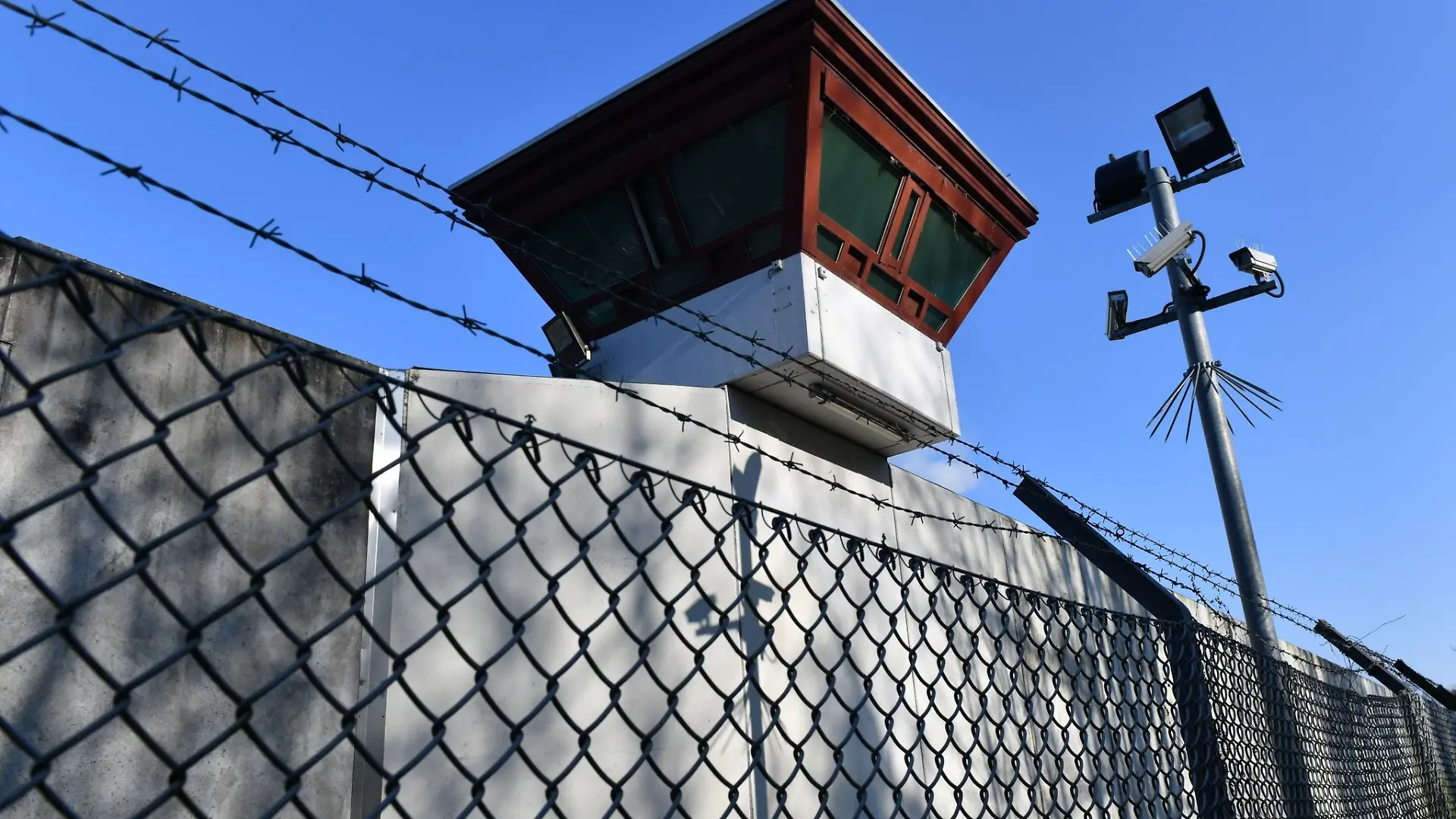 Sicherheitsleuchten und Kameras vor einem Gebäude auf dem Gelände der JVA Tegel.