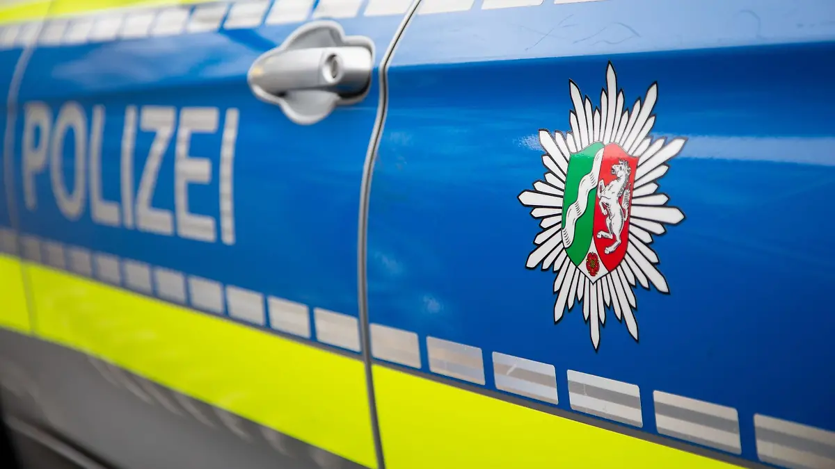 Blick auf ein Emblem der Polizei in NRW an einem Polizeiauto.