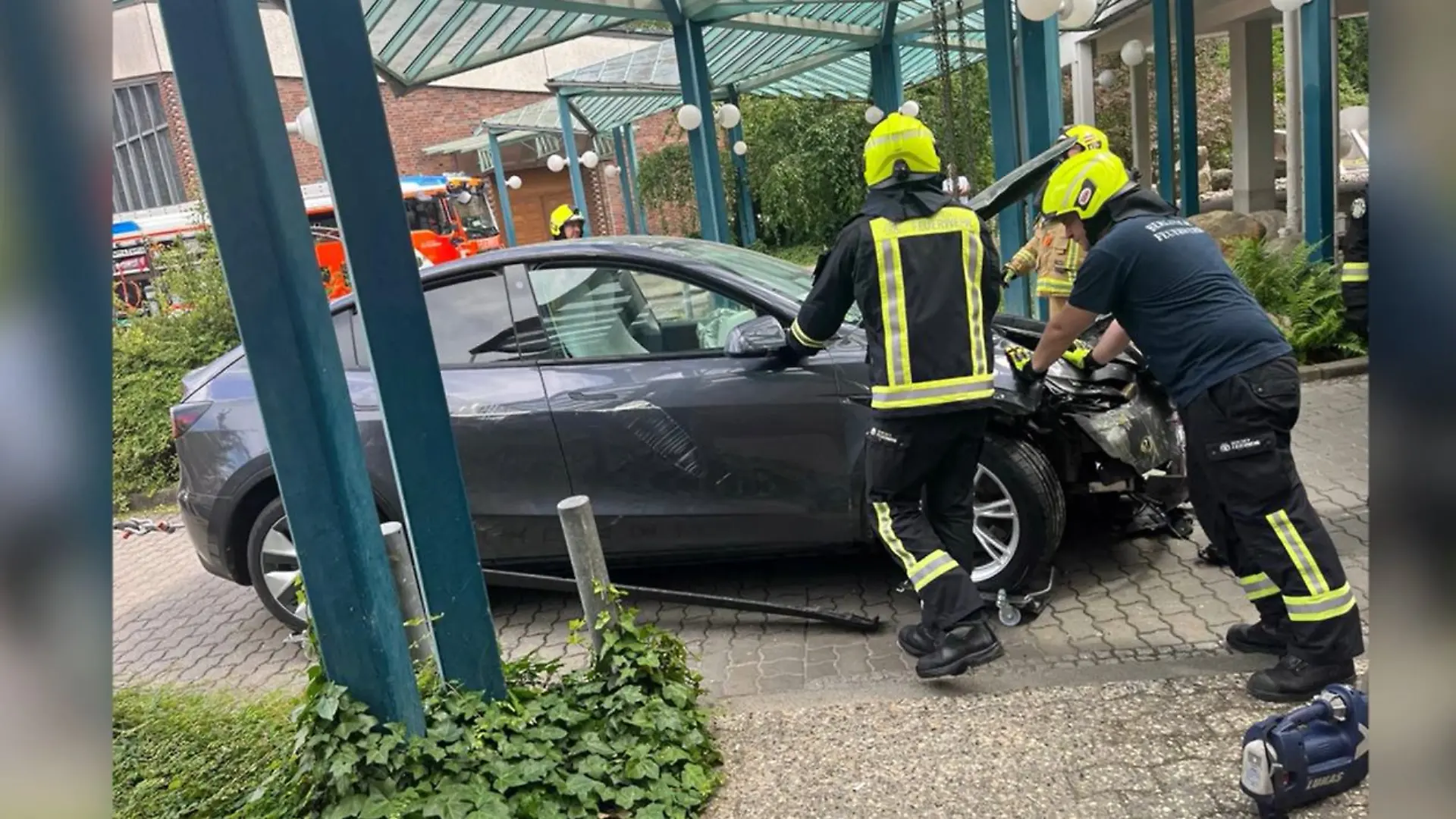 Feuerwehrmänner ziehen den Tesla aus dem Krankenhaus.