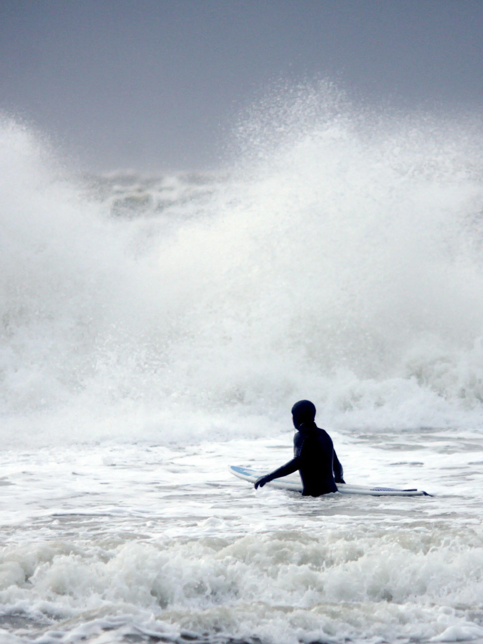 Bei Windgeschwindigkeiten von bis zu 80 Stundenkilometern geht am Donnerstag (29.12.2011) vor der tosenden Brandung an der Südspitze von Sylt bei Hörnum ein Wellenreiter ins Wasser. Die Nordsee hat eine Wassertemperatur von fünf Grad. Für die kommenden Tage sagen die Meteorologen weiterhin regnerisches Wetter bei Temperaturen um fünf Grad voraus. Foto: Kay Nietfeld dpa/lno  +++(c) dpa - Bildfunk+++