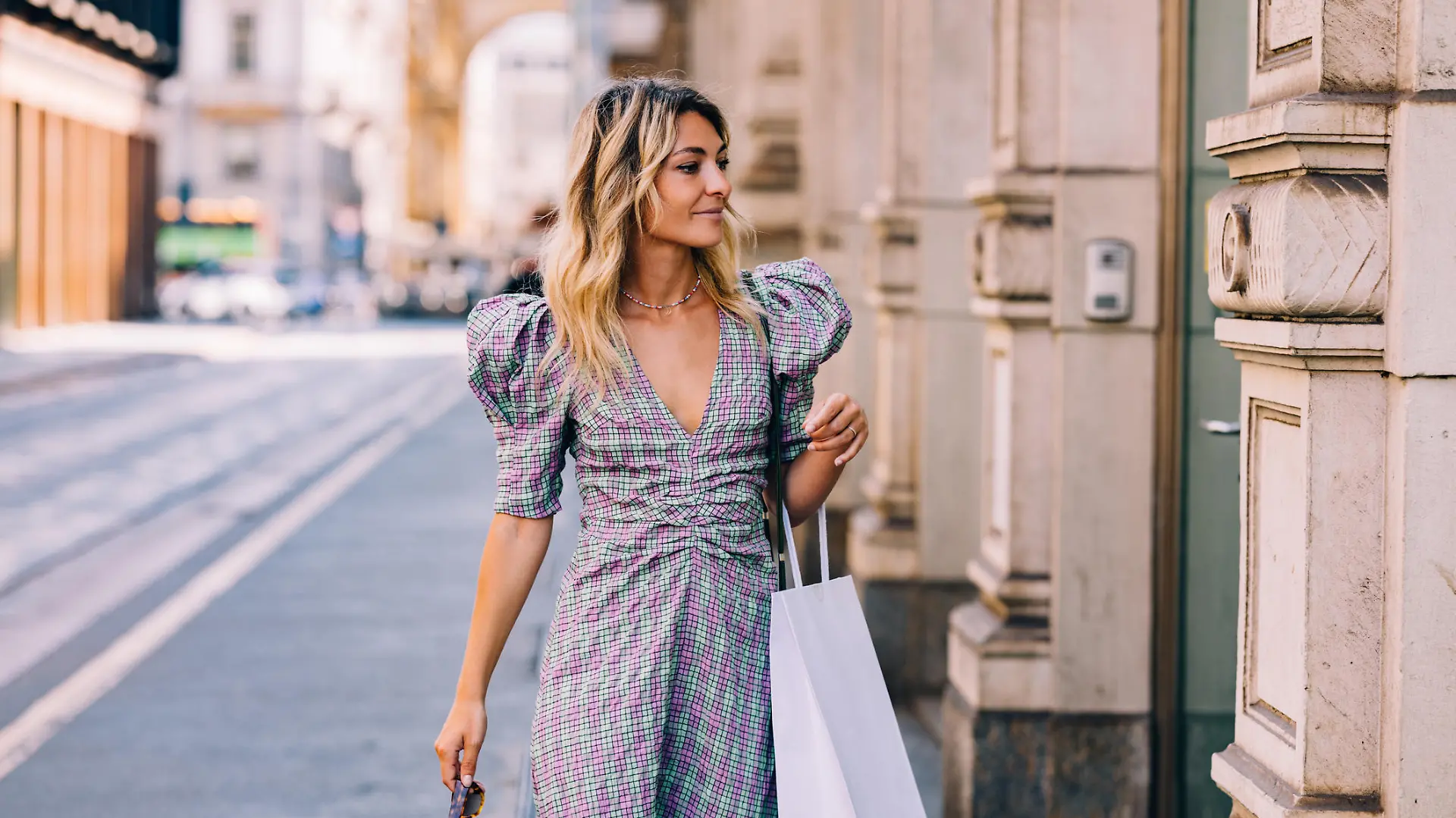 A pretty Caucasian shopaholic with a paper bag going shopping.