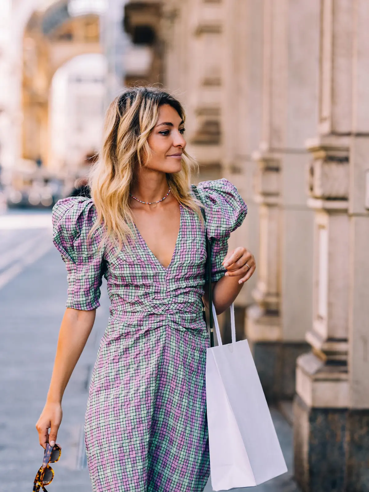 A pretty Caucasian shopaholic with a paper bag going shopping.