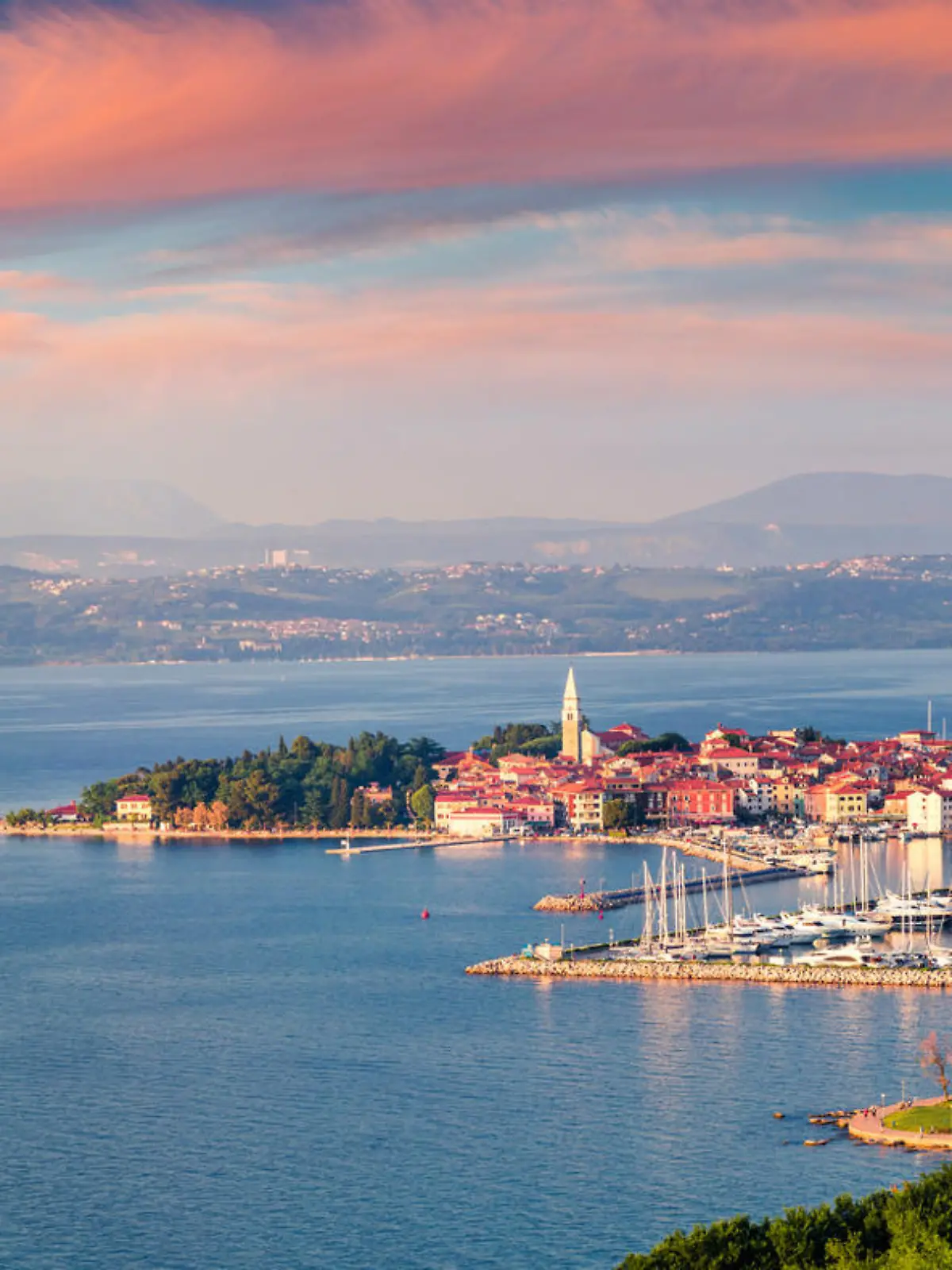 Aerial view of old fishing town Izola. Impressive spring sunset in Slovenia, Europe. Beautiful seascape Adriatic Sea. Traveling concept background.