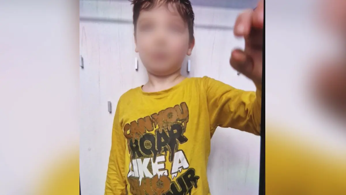Ein kleiner Junge in gelbem Pulli.