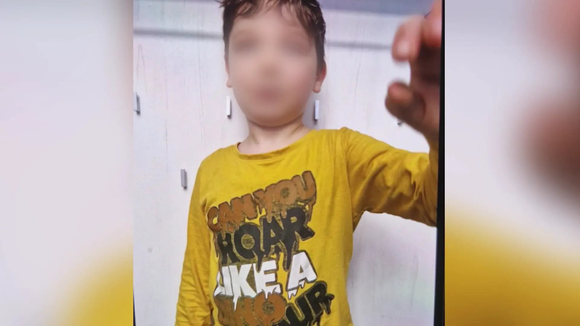 Ein kleiner Junge in gelbem Pulli.