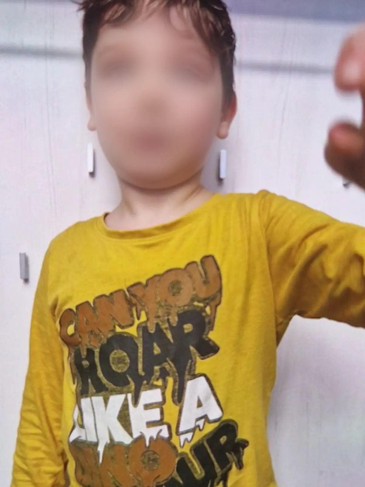 Ein kleiner Junge in gelbem Pulli.