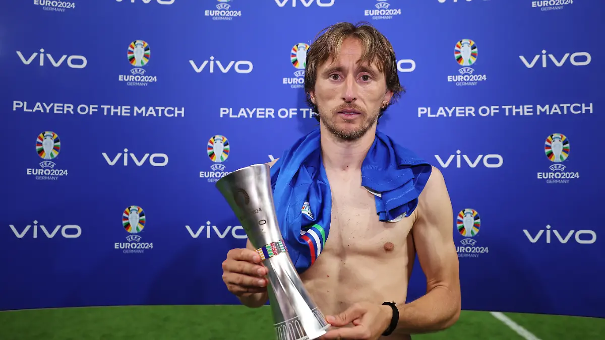 Nach dem 1:1 gegen Italien wird Kroatien-Kicker Luka Modric zum „Spieler des Spiels” geehrt und posiert mit feuerroten Augen für die Fotografen.