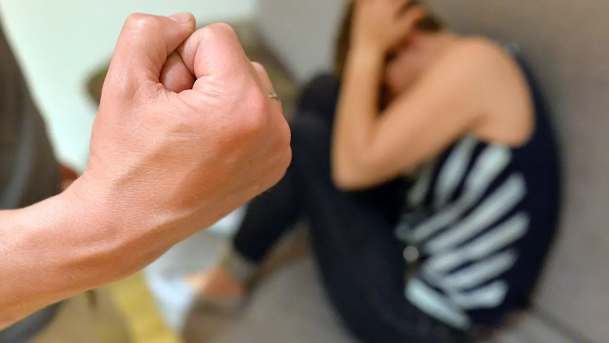 Eine Frau versucht, sich vor der Gewalt eines Mannes zu schützen.