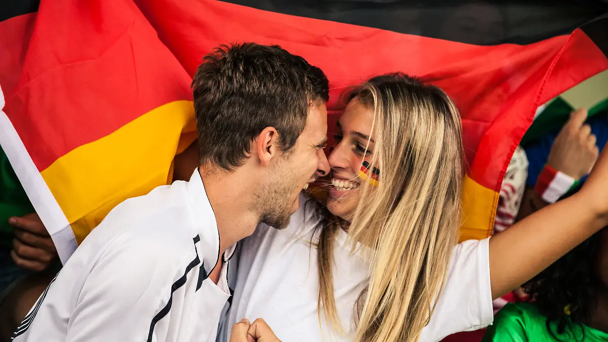 Zwei Deutschland-Fans küssen sich fast.