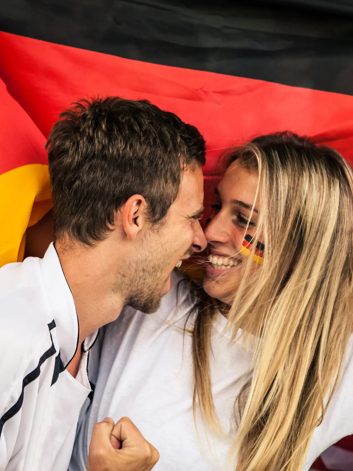 Zwei Deutschland-Fans küssen sich fast.