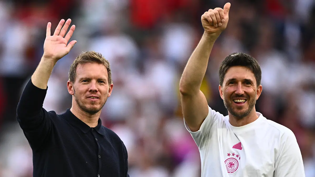 ARCHIV - 19.06.2024, Baden-Württemberg, Stuttgart: Fußball: EM, Deutschland - Ungarn, Vorrunde, Gruppe A, Spieltag 2, Stuttgart Arena, Bundestrainer Julian Nagelsmann (l) und Co-Trainer Benjamin Glück winken nach dem Spiel. (zu dpa: «Der Nagelsmann-Kosmos: Enge Vertraute im großen Rollenspiel») Foto: Tom Weller/dpa +++ dpa-Bildfunk +++