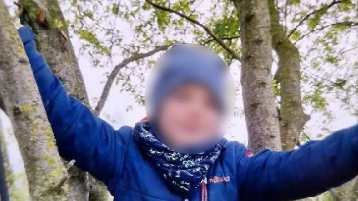 Ein Junge in einer blauen Jacke.
