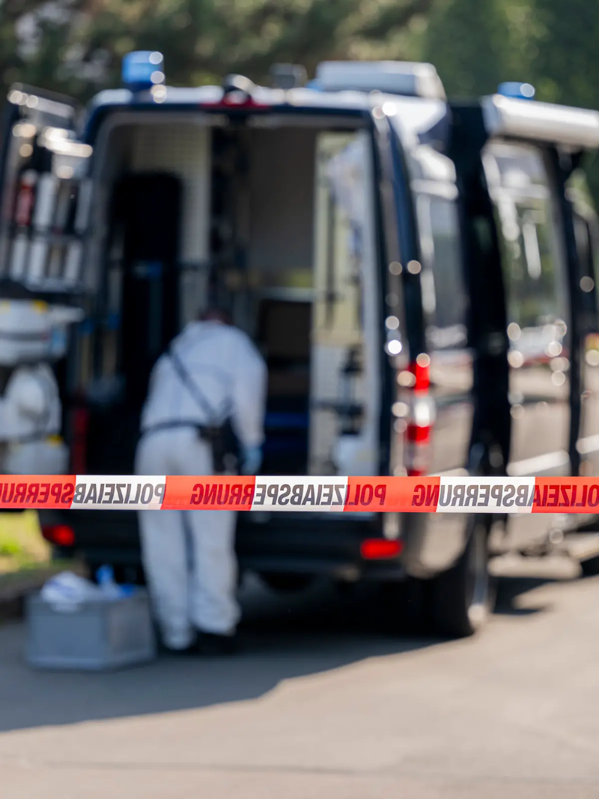 27.06.2024, Thüringen, Erfurt: Ein Mitarbeiter der Spurensicherung ist vor einem Einsatzfahrzeug zu sehen.  Ein Mann wurde in Erfurt erschossen. Der Großeinsatz der Polizei läuft.