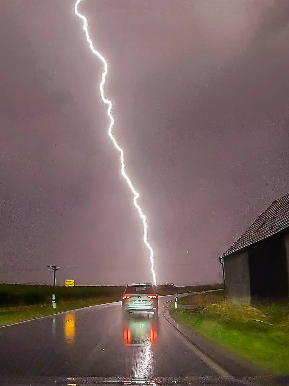 dpatopbilder - 27.06.2024, Bayern, Pförring: Ein Blitz ist am Himmel hinter einer Straße zu sehen. Nach starken Regenfällen im Süden und Südwesten am Mittwoch werden in weiten Teilen des Landes schwere Gewitter mit Unwetterpotential erwartet. Foto: Ferdinand Merzbach/NEWS5/dpa +++ dpa-Bildfunk +++
