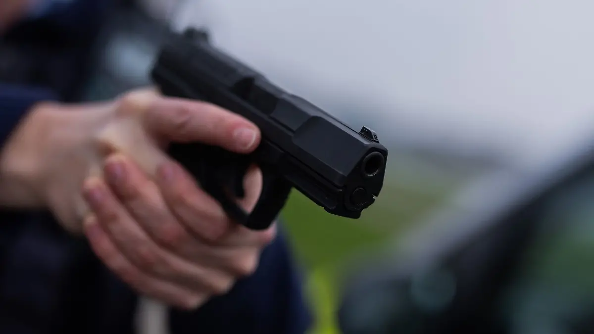 Ein Polizist hält eine Pistole vom Typ Walther P99 in den Händen.