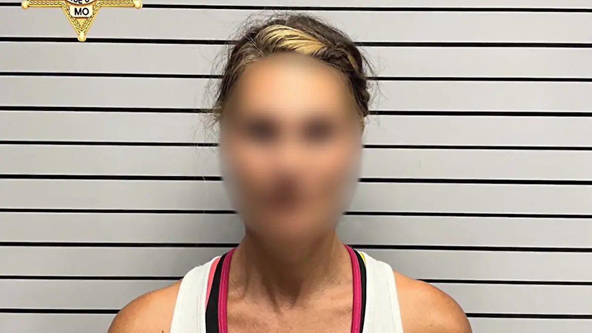 Eine blonde Frau auf einem Polizeifoto. 