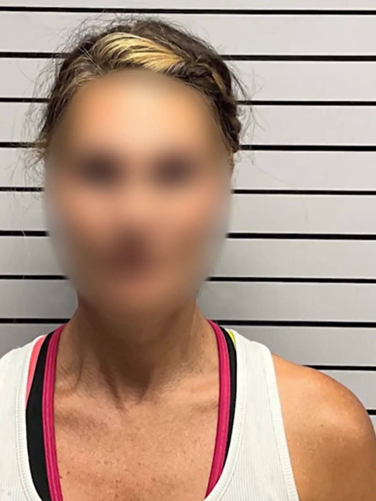 Eine blonde Frau auf einem Polizeifoto. 