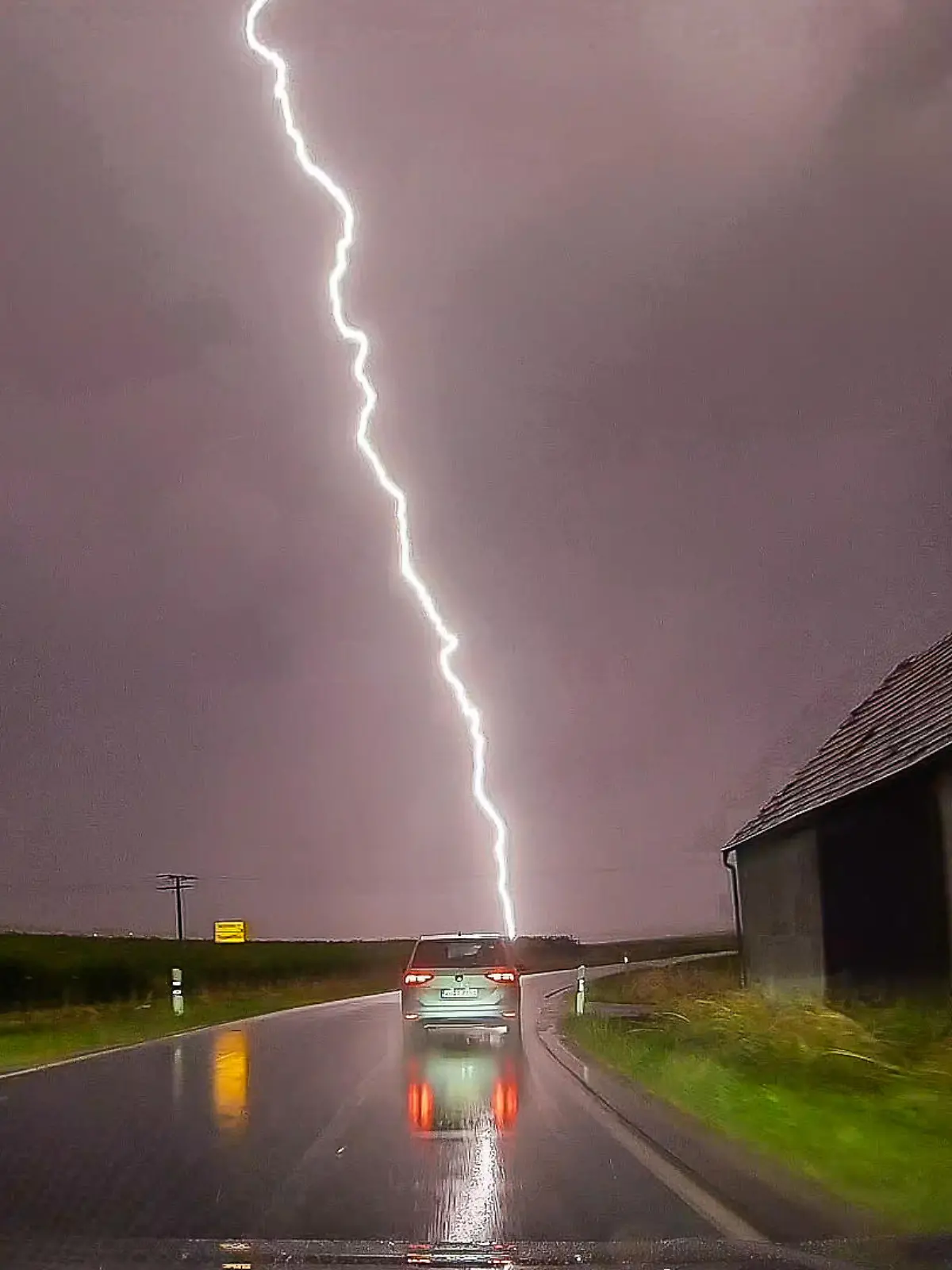 Ein Blitz ist am Himmel hinter einer Straße zu sehen. Nach starken Regenfällen im Süden und Südwesten am Mittwoch werden in weiten Teilen des Landes schwere Gewitter mit Unwetterpotential erwartet.