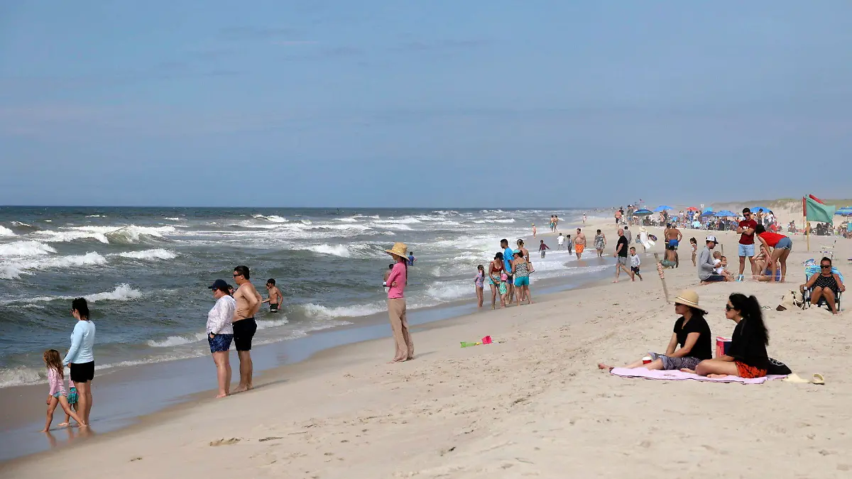 People are seen at Field 3 at Robert Moses State Park in West Islip, N.Y., Tuesday, July 4, 2023. Two swimmers were apparently attacked by sharks off the shores of Long Island on Tuesday, a day after two others reported being attacked while enjoying the water at popular New York beaches. (James Carbone/Newsday via AP)