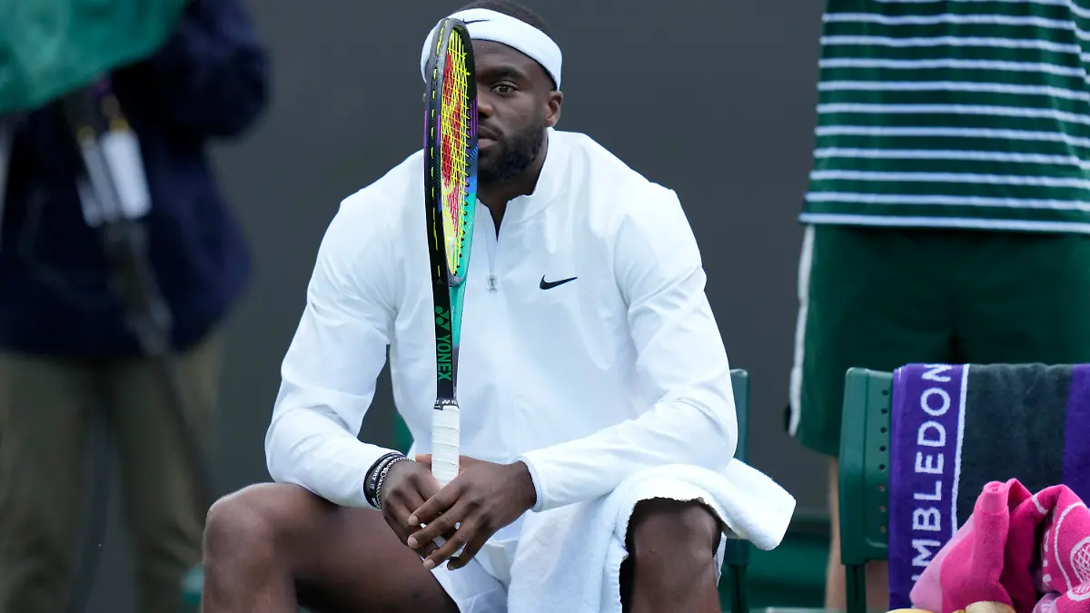 Frances Tiafoe of the US waits for a restart in his match against China's Wu Yibing in a first round men's singles match on day three of the Wimbledon tennis championships in London, Wednesday, July 5, 2023. (AP Photo/Kirsty Wigglesworth)