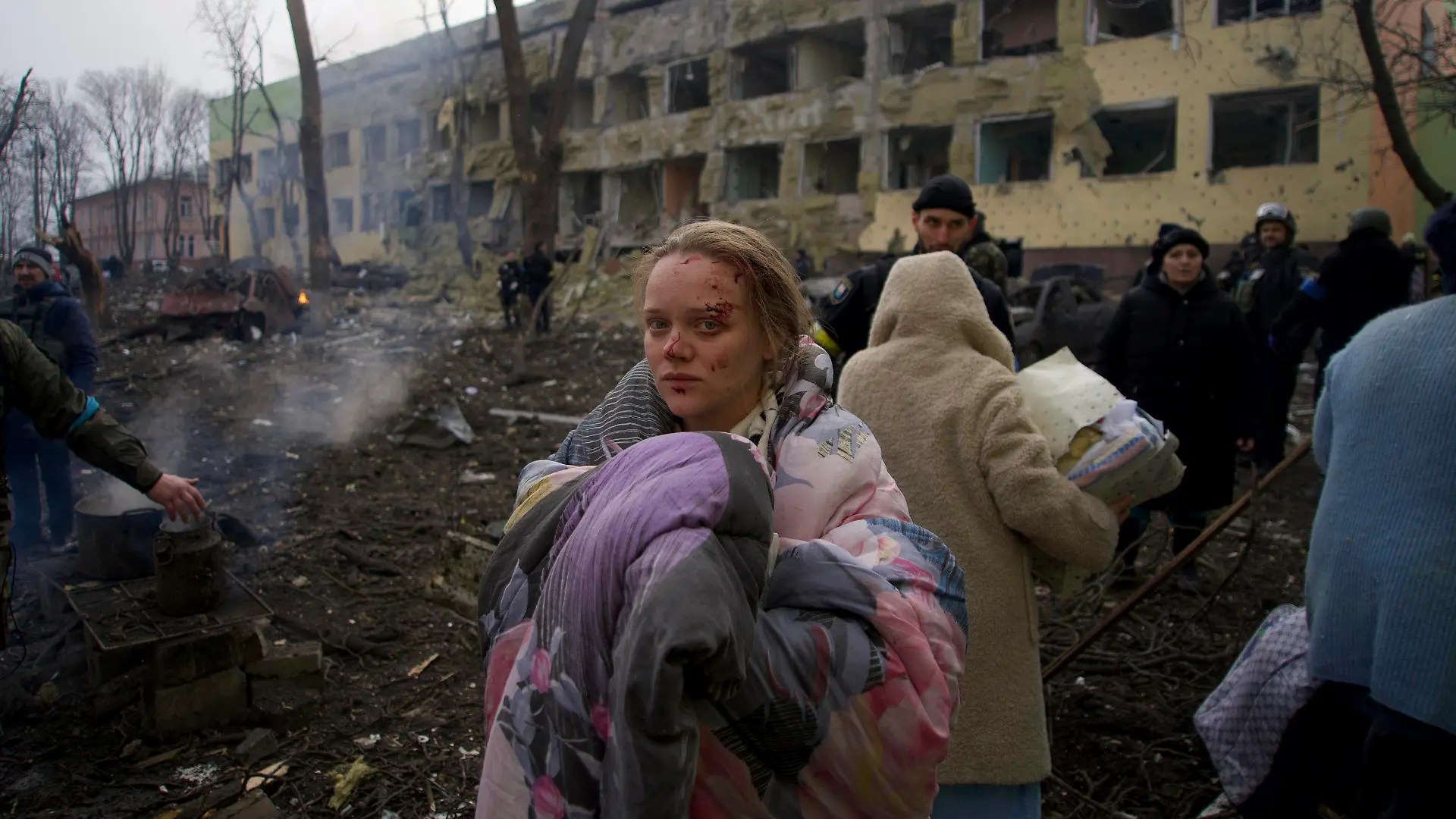 09.03.2022, Ukraine, Mariupol: Mariana Vishegirskaya steht vor einem durch Beschuss beschädigten Entbindungskrankenhaus. Vishegirskaya überlebte den Beschuss und brachte später in einem anderen Krankenhaus in Mariupol ein Mädchen zur Welt. Belagerung, Bombenhagel und kein rettender Ausweg: Die Hilferufe aus der ukrainischen Hafenstadt Mariupol - Heimat von mehr als 400 000 Menschen - werden dramatischer. Foto: Mstyslav Chernov/AP/dpa - ACHTUNG: Graphic Content +++ dpa-Bildfunk +++