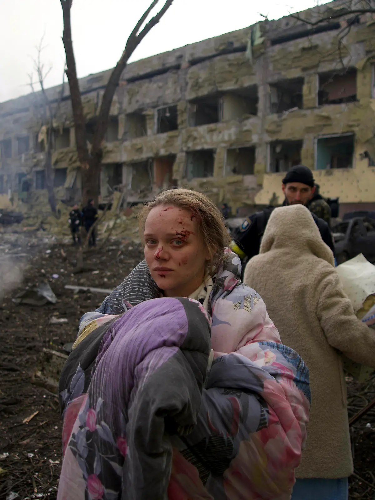 09.03.2022, Ukraine, Mariupol: Mariana Vishegirskaya steht vor einem durch Beschuss beschädigten Entbindungskrankenhaus. Vishegirskaya überlebte den Beschuss und brachte später in einem anderen Krankenhaus in Mariupol ein Mädchen zur Welt. Belagerung, Bombenhagel und kein rettender Ausweg: Die Hilferufe aus der ukrainischen Hafenstadt Mariupol - Heimat von mehr als 400 000 Menschen - werden dramatischer. Foto: Mstyslav Chernov/AP/dpa - ACHTUNG: Graphic Content +++ dpa-Bildfunk +++