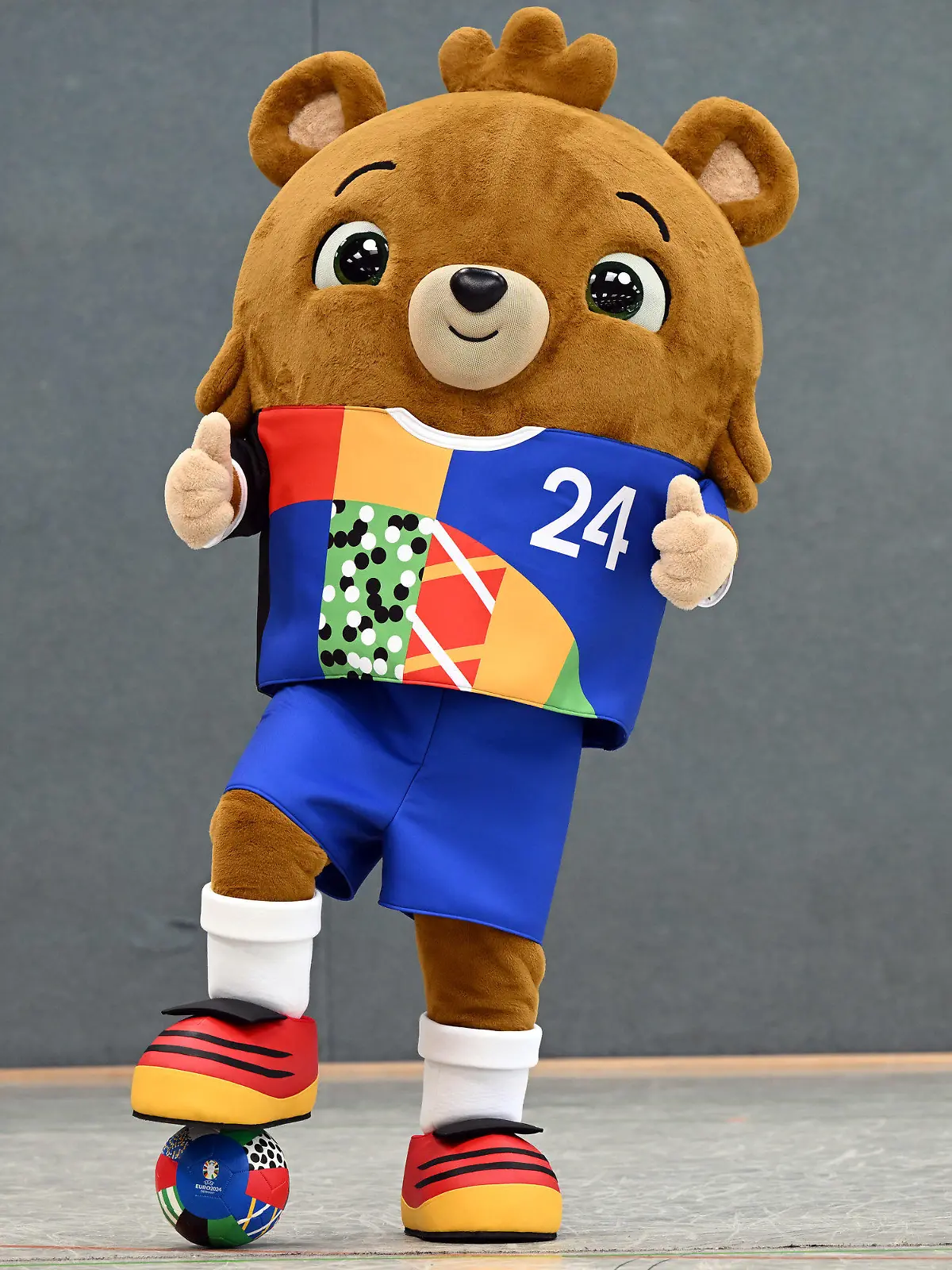 ARCHIV - 20.06.2023, Nordrhein-Westfalen, Gelsenkirchen: Fußball: EM 2024, Vorstellung des offiziellen Maskottchens. Das noch namenlose Maskottchen steht in einer Sporthalle. Ein putziger kleiner Bär - mit Hose. Die EM 2024 in Deutschland soll nachhaltig werden.. (zu dpa: «Organisatoren mit Nachhaltigkeitszielen für Fußball-EM») Foto: Federico Gambarini/dpa +++ dpa-Bildfunk +++