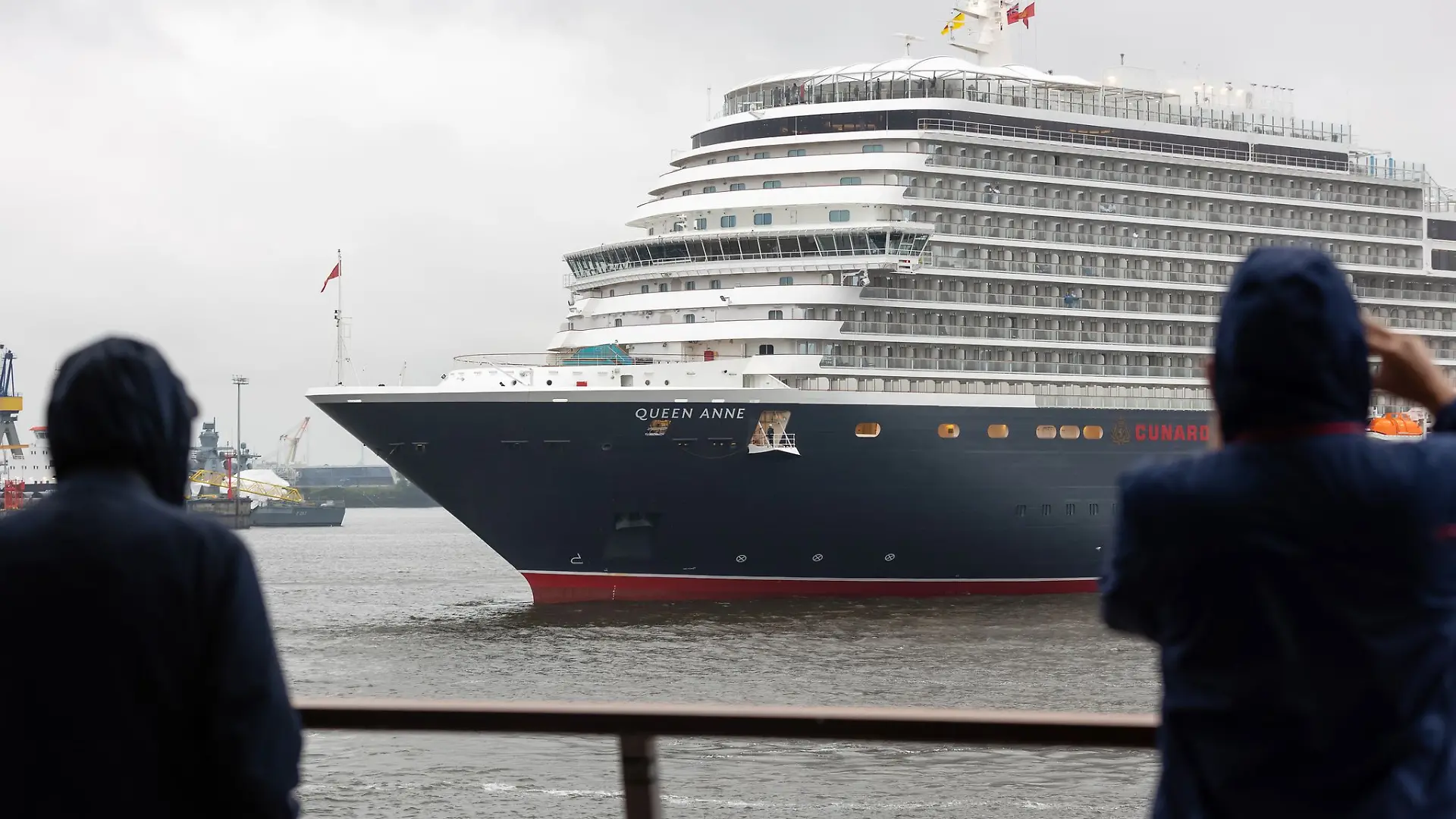 Trotz Schmuddelwetters lassen es sich Schaulustige nicht nehmen, das neue Kreuzfahrtschiff «Queen Anne» beim ersten Anlauf in Hamburg zu begrüßen