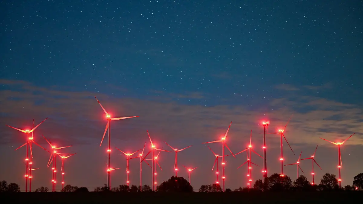 dpatopbilder - PRODUKTION - 06.05.2022, Brandenburg, Jacobsdorf: Die roten Positionslichter an Windenergieanlagen erhellen den Nachthimmel und die Landschaft. Angestrahlte Kirchen und Denkmäler, Flutlicht im Stadien und grelle Straßenbeleuchtung - die Menschen machen vielerorts die Nacht zum Tag, mit verheerenden Folgen für die Tierwelt und die Artenvielfalt. (zu dpa-KORR.: "Schattenseite des Lichts: Lichtverschmutzung wird für Tiere zur Qual") Foto: Patrick Pleul/dpa +++ dpa-Bildfunk +++
