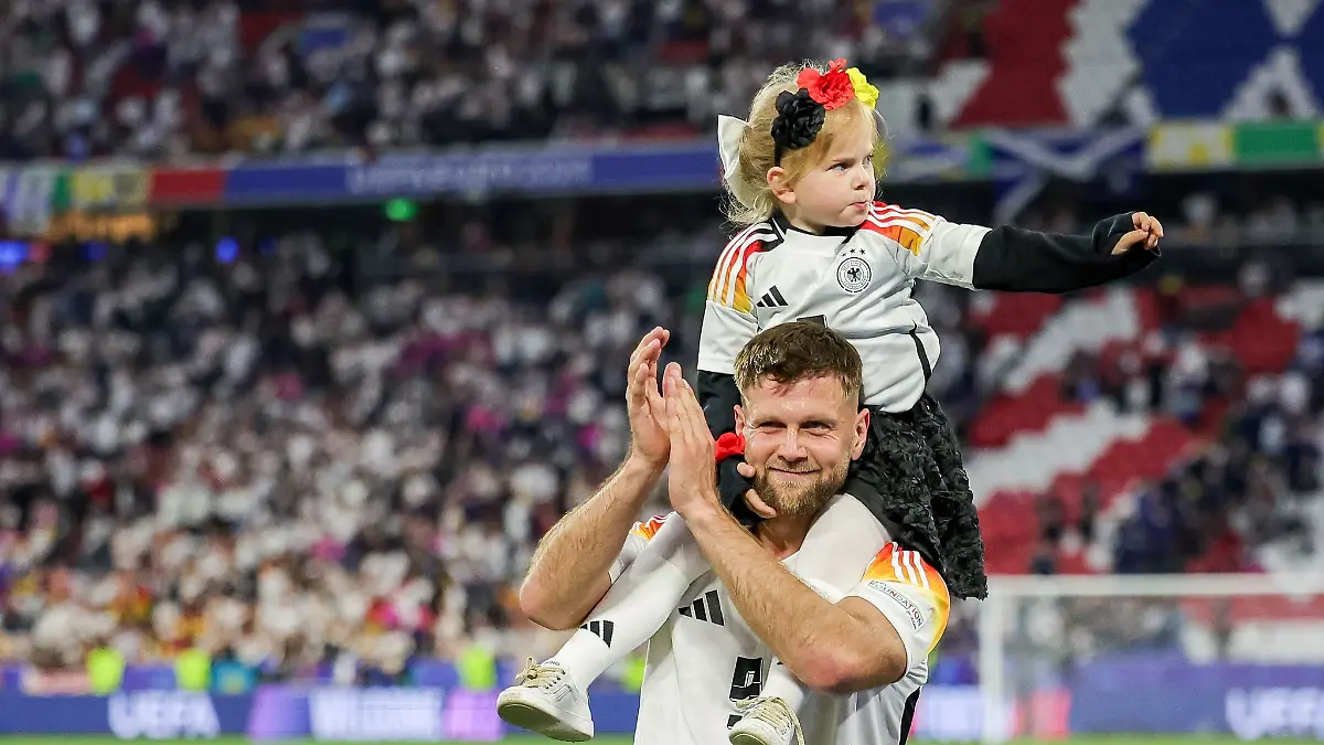 Niclas Füllkrug trägt nach dem ersten EM-Spiel der Deutschen seine Tochter Emilia durch das Stadion.
