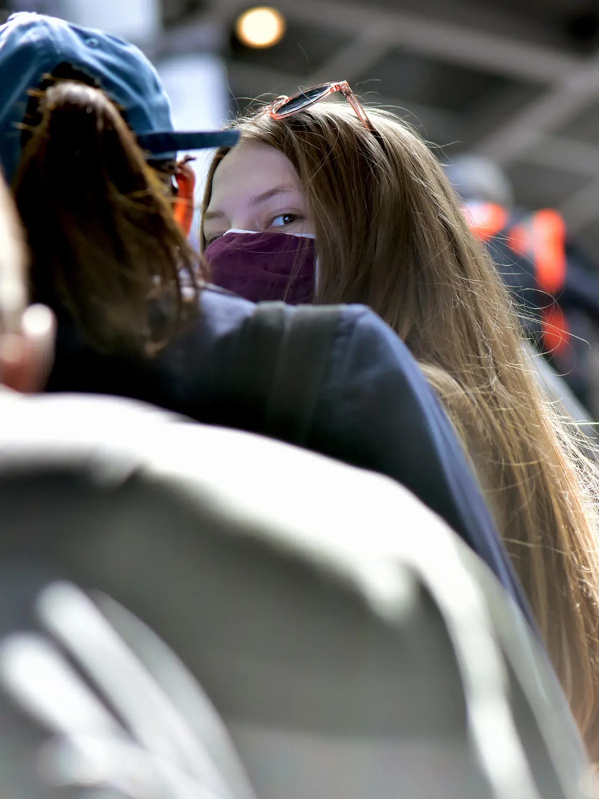Eine junge Frau mit Mundschutz auf einer Rolltreppe im Bahnhof Südkreuz, aufgenommen am 31.05.2020. Foto: Matthias Tödt/dpa-Zentralbild/ZB