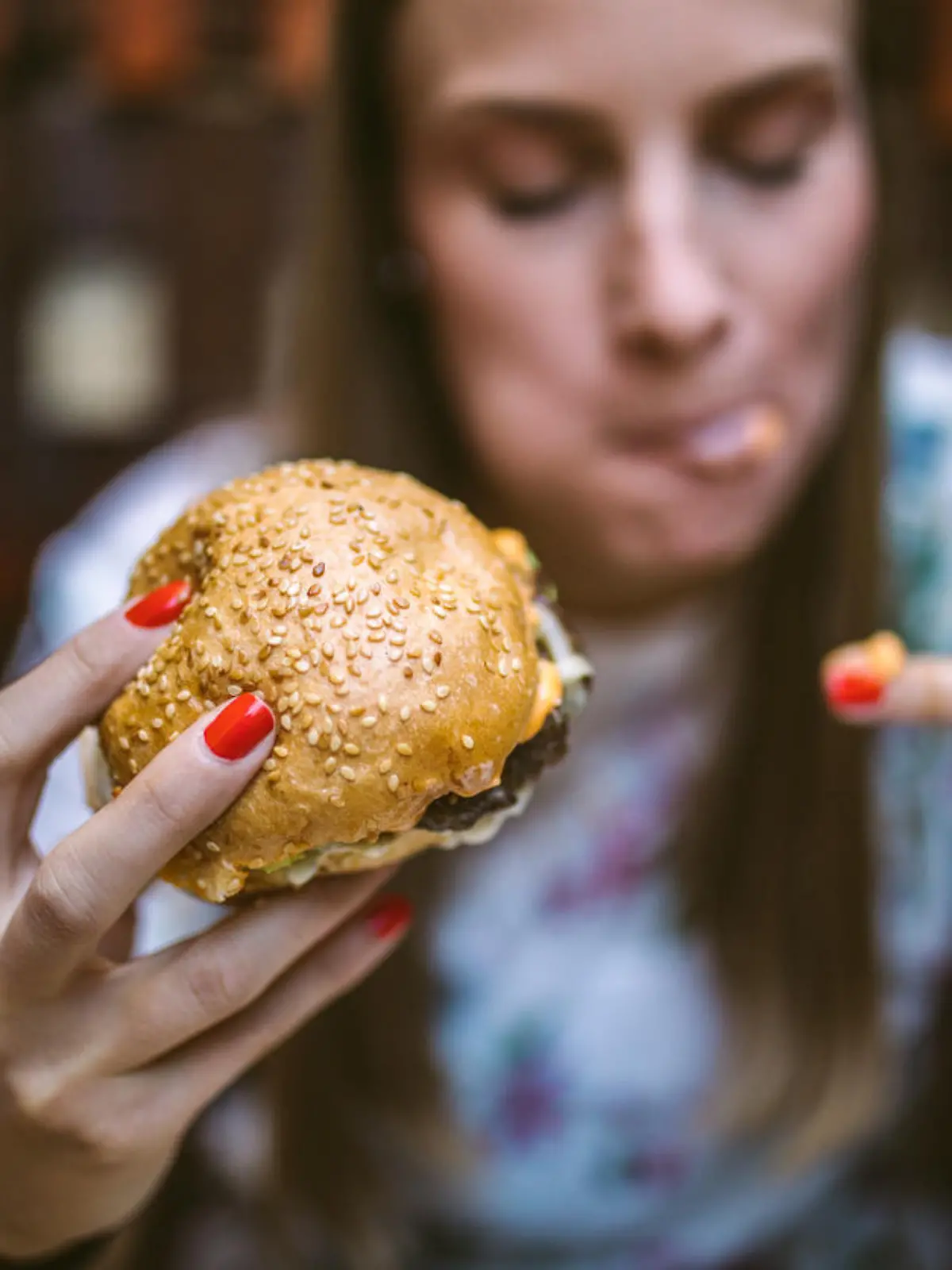 Gourmand Girl Eating Tasty Hamburger at Fast Food Restaurant