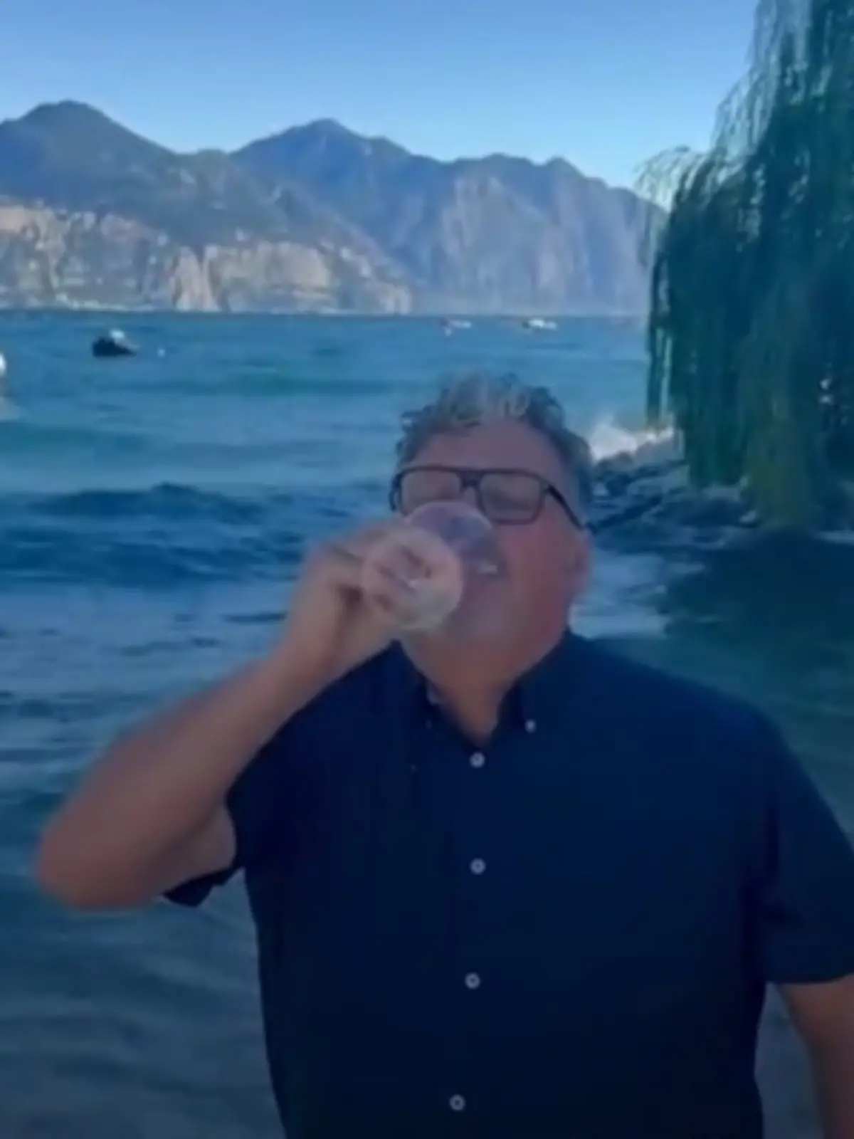 Paolo Formaggioni,, Bürgermeister der Gardasee-Gemeinde Brenzone, trinkt ein Glas Wasser aus dem See
